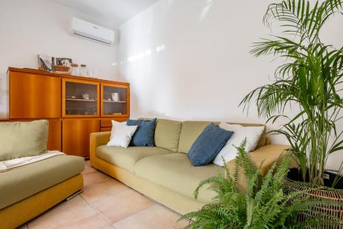 a living room with a couch and two plants at Villa Golden Lake 2 - just few steps from the lake in Dervio