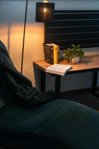 a desk with a telephone and a book on it at Apartamenty Blisko Słońca - Jacuzzi, Playgrounds in Nowy Targ