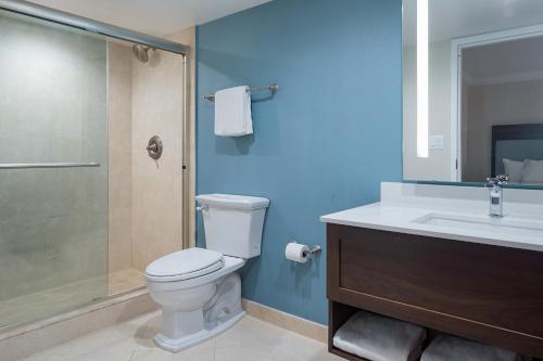 a bathroom with a toilet and a sink and a shower at The Atlantic Suites on the Ave in Delray Beach