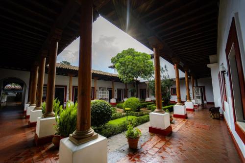 a building with a courtyard with plants and a tree at Best Western Plus Posada de Don Vasco in Pátzcuaro