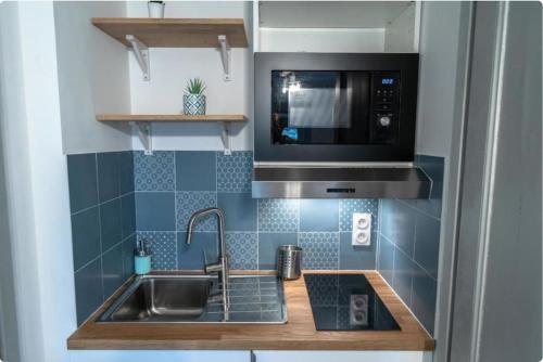 une cuisine avec un évier et un micro-ondes dans l'établissement Lafayette, Charmant, à Lyon