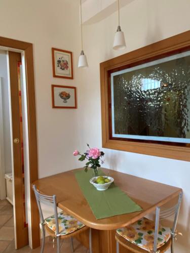 a dining room table with a vase of flowers on it at Rhome country lodge in La Massimina-Casal Lumbroso