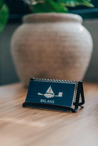 a black wallet sitting on top of a table with a vase at Balans nad Jeziorem in Ślesin
