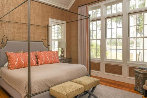 a bedroom with a canopy bed and windows at Signature 5 Bedroom Lagoon Residence 1003 in Bluffton