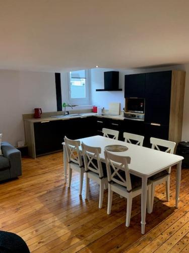 une table blanche et des chaises dans un salon dans l'établissement Appartement #4 cœur de ville, au Mans