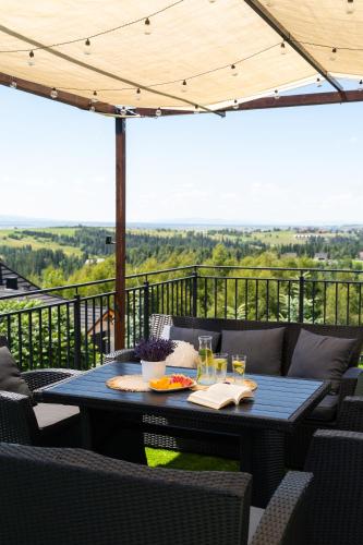 a blue table on a balcony with a view at Apartamenty Blisko Słońca - Jacuzzi, Playgrounds in Nowy Targ
