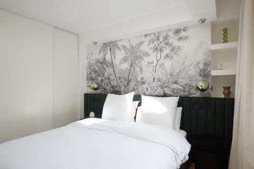 une chambre avec un grand lit avec des draps blancs dans l'établissement Brand New Design Flat - Vendôme, à Paris