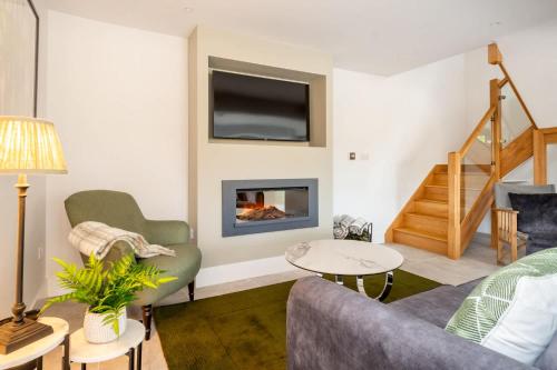 a living room with a couch and a fireplace at The Lodge Private Parking & Garden in Cheltenham