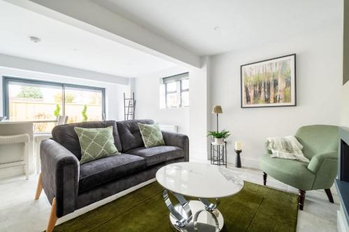 a living room with a couch and a table at The Lodge Private Parking & Garden in Cheltenham
