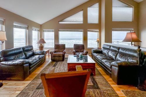 a living room with leather couches and a table at The Beach House in Lincoln City