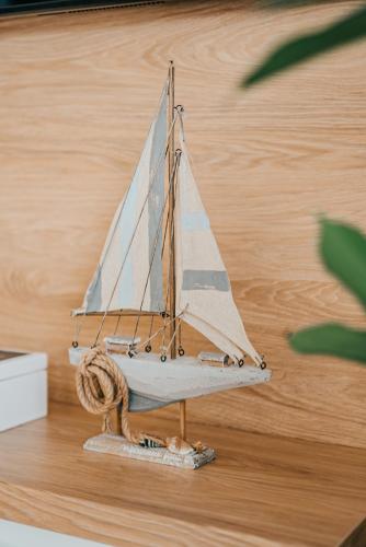 a wooden model of a sail boat on a wooden floor at Balans nad Jeziorem in Ślesin