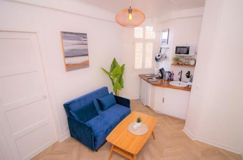 un salon avec une chaise bleue et une table dans l'établissement Appartement tout équipé Paris-Colombes- La défense, à Colombes