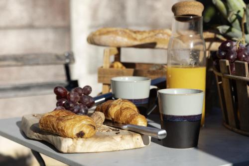 une table avec des croissants et une bouteille de jus d'orange dans l'établissement Maison COSY et CHALEUREUSE au centre ville, à Mont-de-Marsan