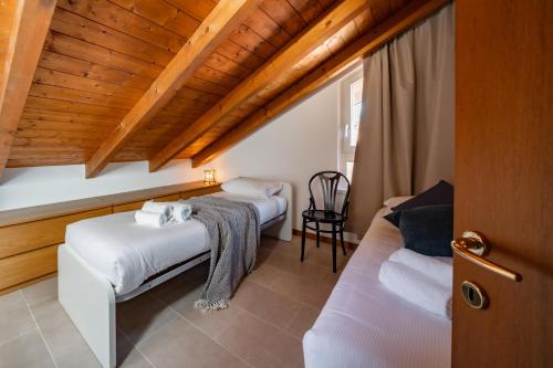 a bedroom with two beds and a wooden ceiling at Villa Golden Lake 2 - just few steps from the lake in Dervio