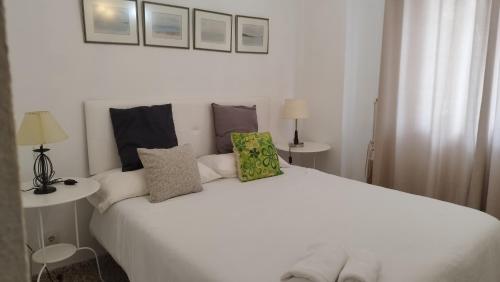 a white bed with pillows on it in a room at URBION HOME in Seville