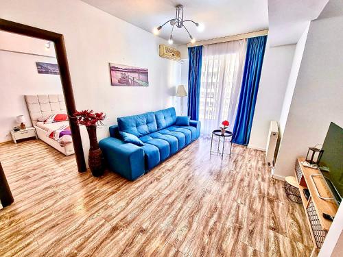 a living room with a blue couch and a bed at Summerland Seaview Apartments in Mamaia
