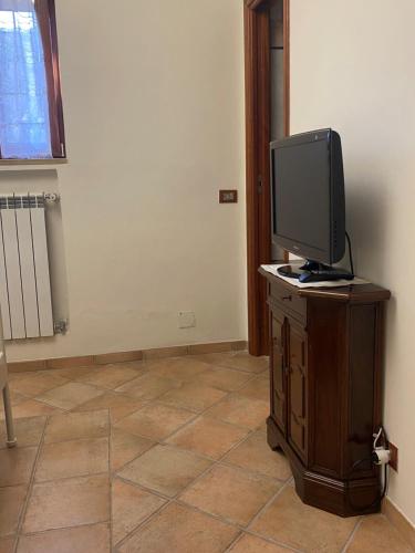a television sitting on a wooden stand in a room at Rhome country lodge in La Massimina-Casal Lumbroso