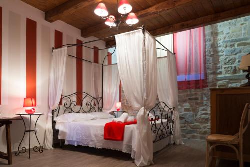 a bedroom with a canopy bed with red accents at Locanda Mammi' in Agnone