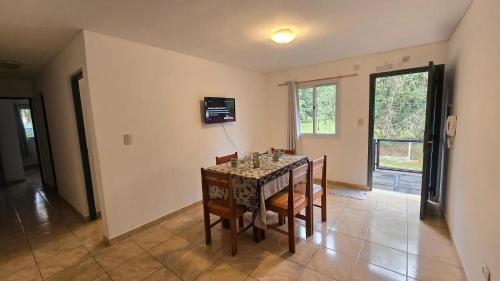 ein Esszimmer mit Tisch und Stühlen und einem Fenster in der Unterkunft Las Palmas Village in Puerto Iguazú