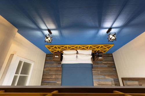 a bed in a room with lights on the ceiling at Prixma Hotel in San Andrés