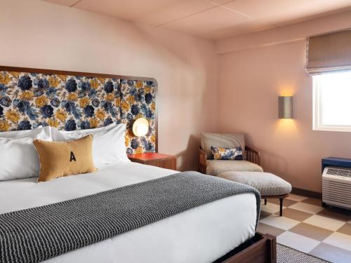 a hotel room with a bed and a chair at ARRIVE Albuquerque in Albuquerque