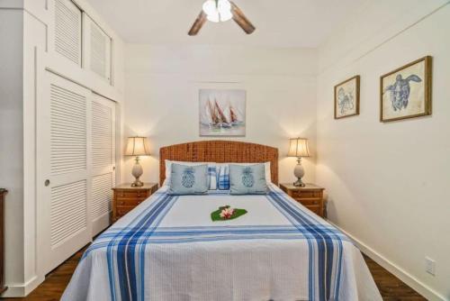 a bedroom with a bed with blue and white sheets at New remodeled Kiahuna Paradise condo in Koloa