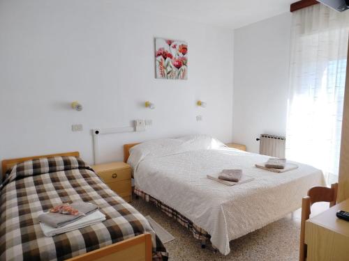a bedroom with two beds with towels on them at Hotel Veles in Querciola