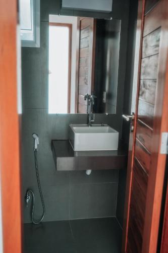 a bathroom with a sink and a mirror at Quality - Boas Vistas in Canoa Quebrada