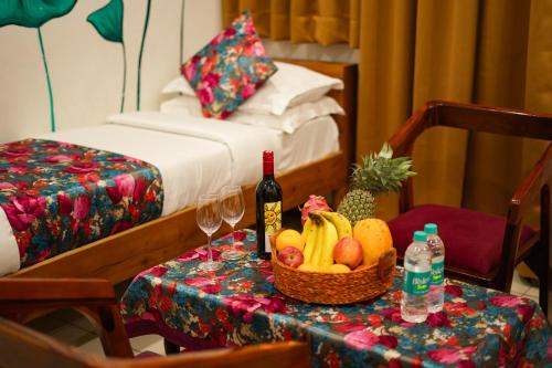 a table with a basket of fruit and wine bottles at PETAL OF MEWAR - A Luxury Boutique Hotel in Udaipur