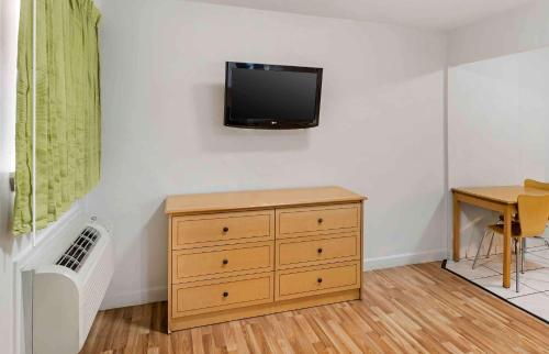 a room with a dresser and a tv on a wall at Extended Stay America Select Suites - Odessa in Odessa