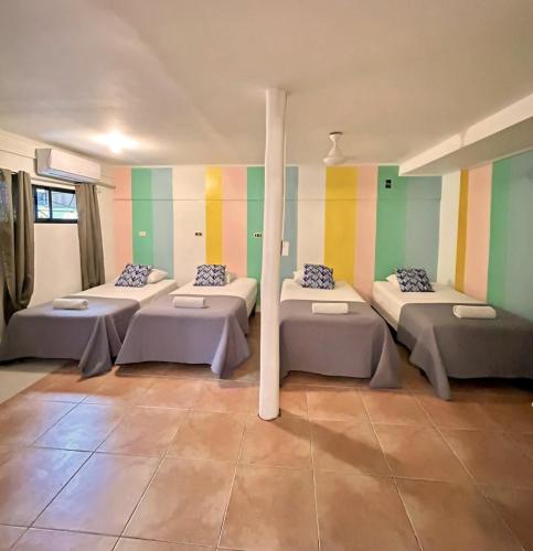 a room with four beds in it with colorful walls at Point Break Santa Teresa in Santa Teresa Beach