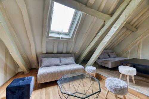 Cette chambre comprend un canapé, une table et des chaises. dans l'établissement Damiette charmant F4 centre Rouen St Maclou !, à Rouen