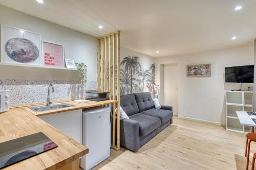 un salon avec un canapé et une cuisine dans l'établissement Antoine joli studio gare de Rouen !, à Rouen
