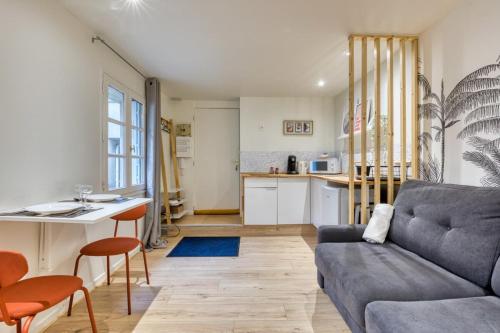 un salon avec un canapé et une cuisine dans l'établissement Antoine joli studio gare de Rouen !, à Rouen