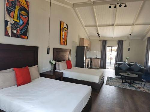 a hotel room with two beds and a chair at Shumba Valley Lodge Lanseria Airport in Lanseria