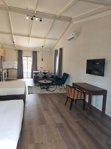 a living room with a bed and a couch and a table at Shumba Valley Lodge Lanseria Airport in Lanseria