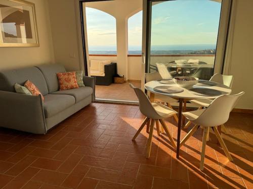 un salon avec un canapé, une table et des chaises dans l'établissement SeaVista Sardinia, à Badesi