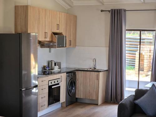 a kitchen with a stainless steel refrigerator and a dishwasher at Shumba Valley Lodge Lanseria Airport in Lanseria