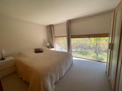 une chambre avec un lit et une grande fenêtre dans l'établissement Duplex 4 personnes, à Chamonix-Mont-Blanc