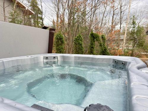 a hot tub with blue water in a backyard at Strasse Ski Chalet Hot Tub Dog-Friendly Skiing in Bartlett