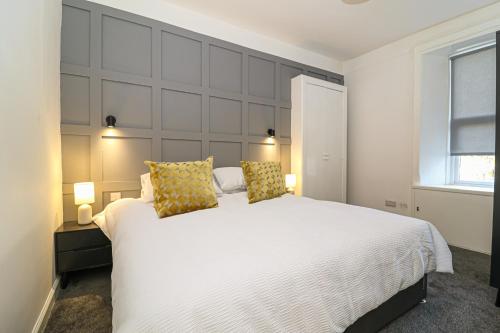 a bedroom with a large white bed with two pillows at 1-Bed Apartment with Sofa Bed in West Kilbride - Long Stays - Free Parking in West Kilbride