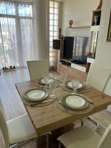 a dining room table with plates and glasses on it at Apartamento Ro & Vi in Águilas