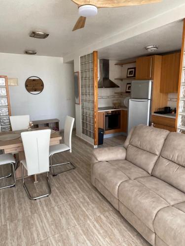 a living room with a couch and a table and a kitchen at Apartamento Ro & Vi in Águilas