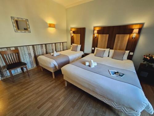 a hotel room with two beds and a chair at Logis Loire Hotel - Les Cocottes Restaurant in Les Rosiers-sur-Loire
