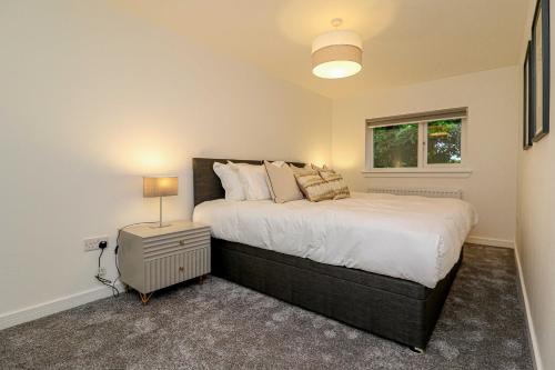 a bedroom with a large bed and a window at Wyndford Riverside House in Glasgow