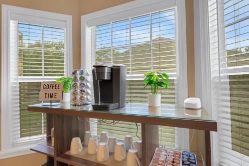 a counter with a coffee maker in a room with windows at Luxury Home with Gourmet Kitchen - 3 Miles to A&M, Sleeps 14 in College Station