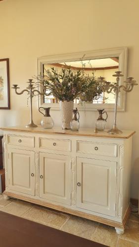 a white cabinet with a mirror and flowers on it at Private Villa with Panoramic View in Ayía Evthimía