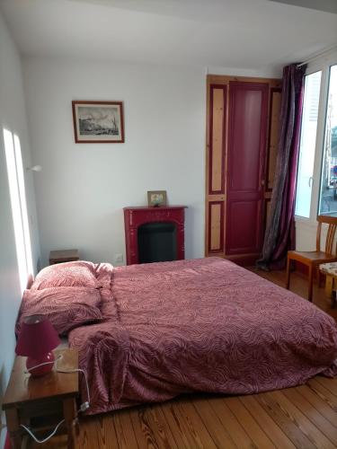 une chambre avec un lit avec une couette rouge dans l'établissement Appartement ancien entièrement rénové plein sud, à Dieppe