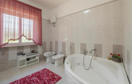 a bathroom with a white tub and a toilet at villa pia in Piumarola