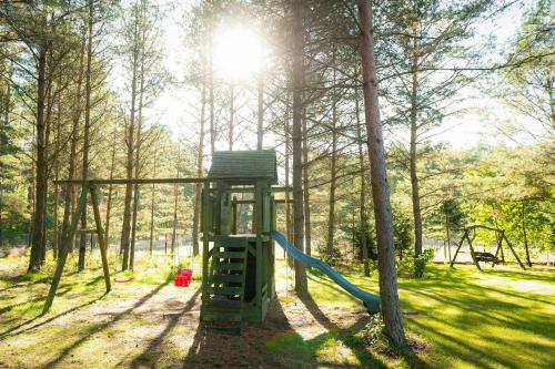 a park with a playground with a slide at LEŚNA STRZECHA APARTAMENTY in Rotembark